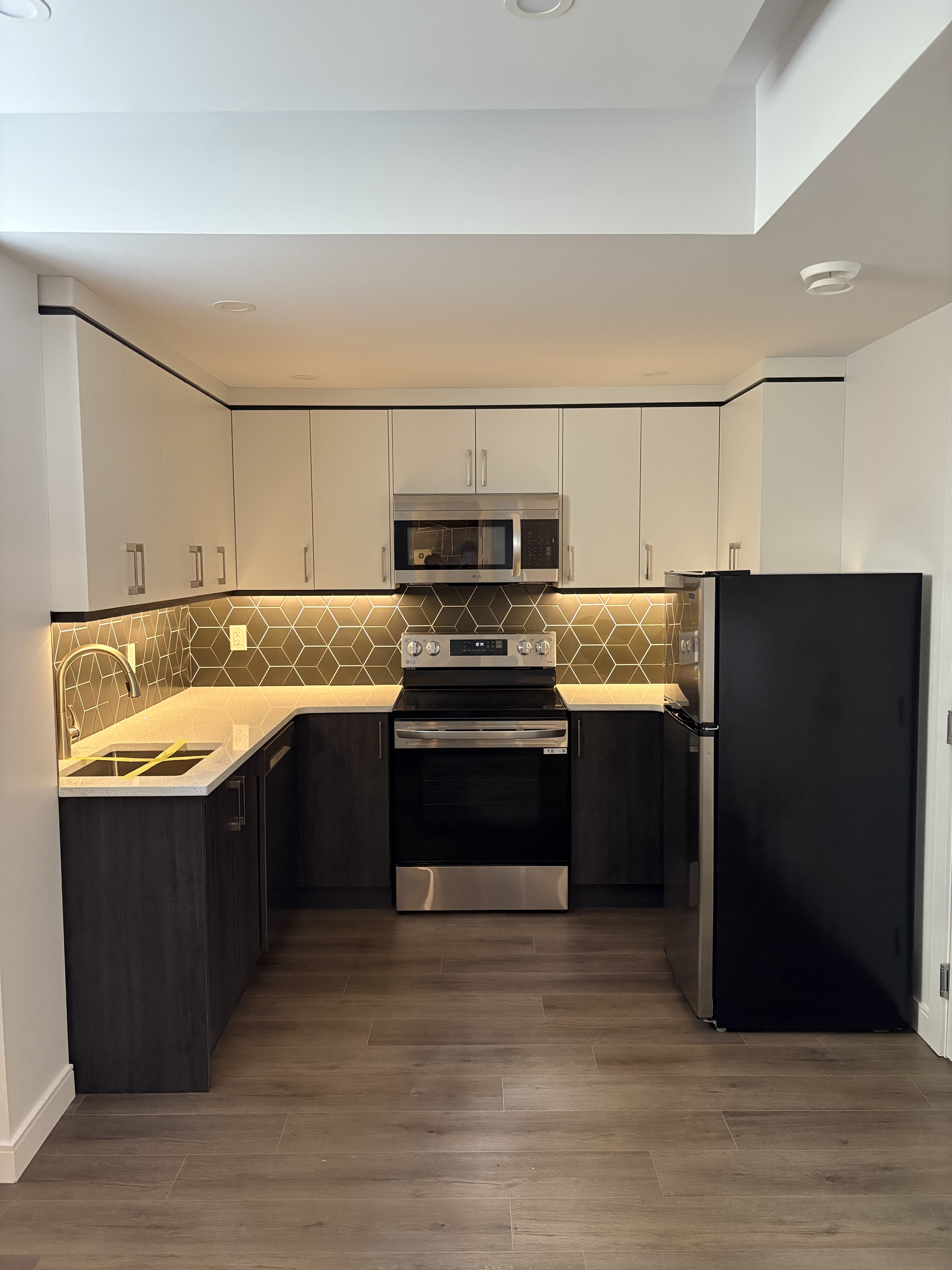 Finished legal suite kitchen with hexagon tile backsplash