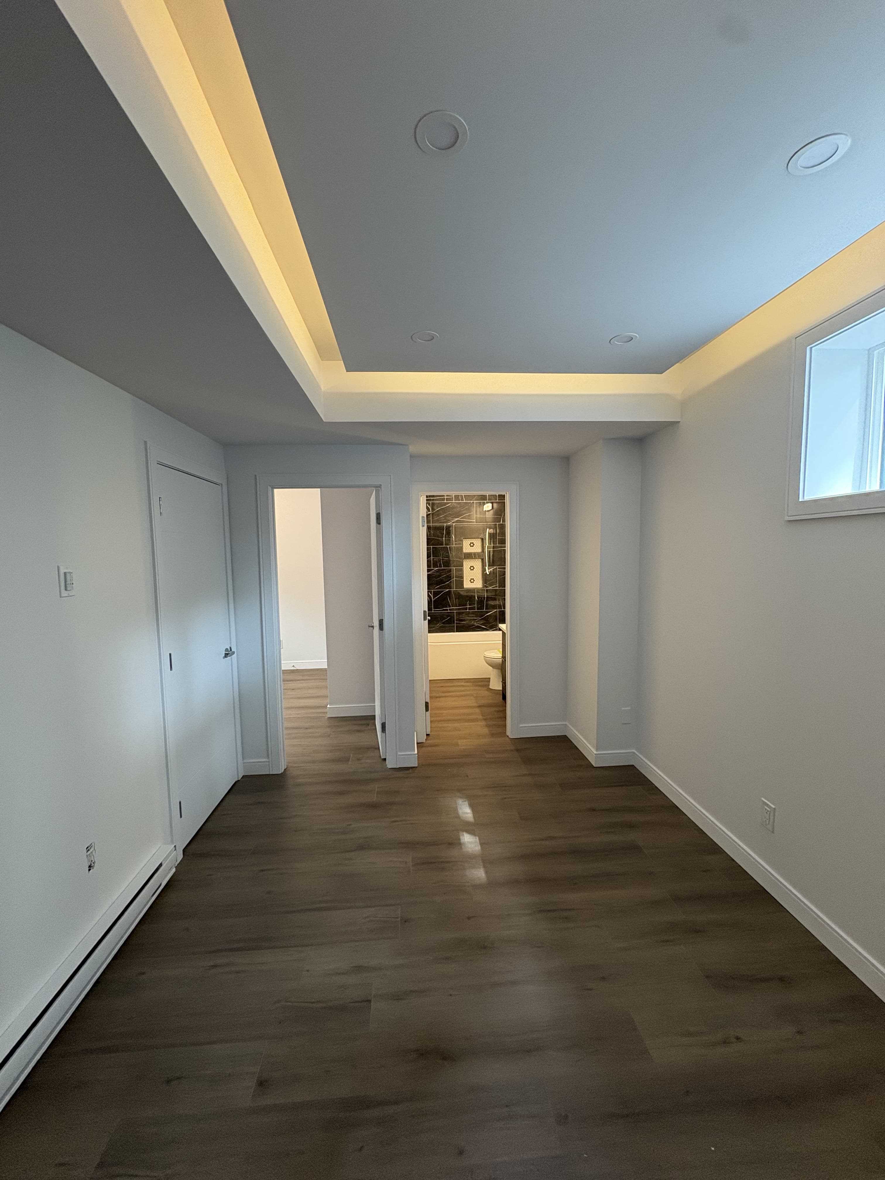 Finished legal suite living area with tray ceiling